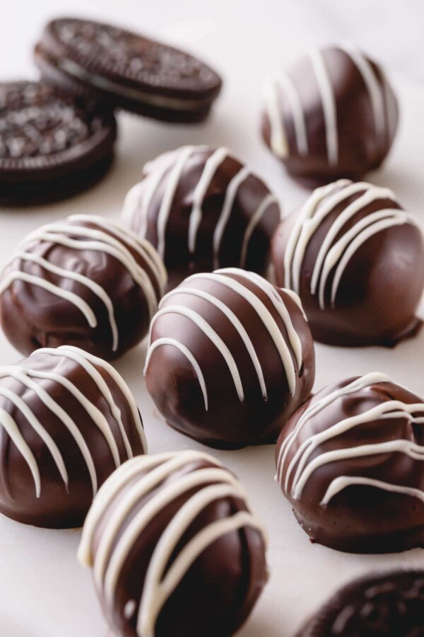 Dark chocolate oreo balls with white chocolate drizzle.