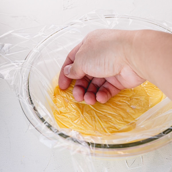 Custard in a bowl, covered with plastic wrap to touch.