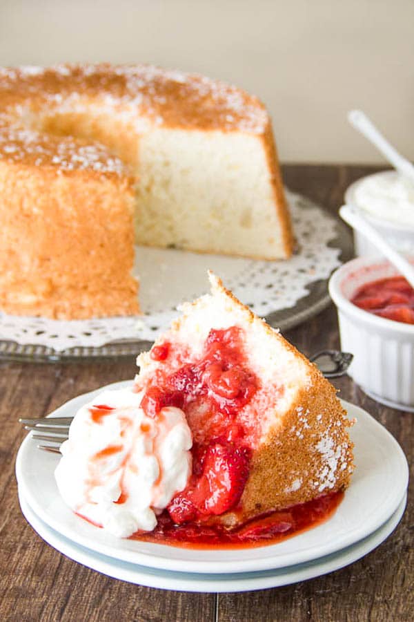 Irresistibly tall and light, this angel food cake is infused with touch of orange zest and served with honey glazed strawberry sauce and whipped cream. A true crowd-pleaser!