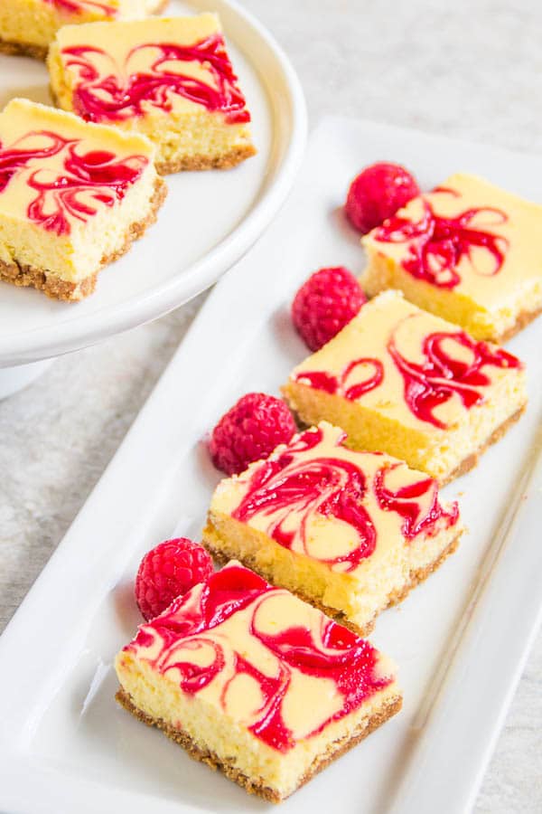 These soufflé-like lemon raspberry cheesecake bars are creamy and soft with burst of honey-glazed raspberry sauce in every bite. Effortlessly impressive dessert!