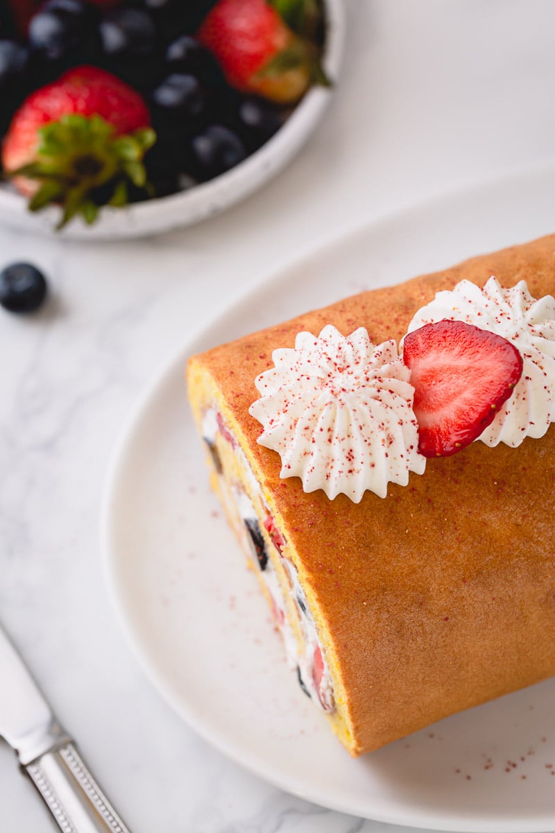 How to make a roll cake, a simpler way. No need to roll the cake while hot, this spring-y sponge cake is super pliable and rolls beautifully without cracks! #rollcake #swissroll