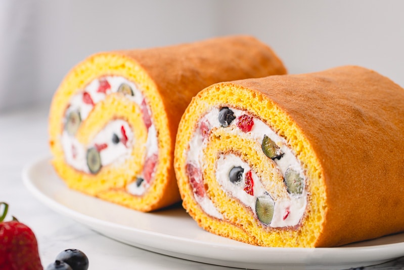 How to make a roll cake, a simpler way. No need to roll the cake while hot, this spring-y sponge cake is super pliable and rolls beautifully without cracks! #rollcake #swissroll