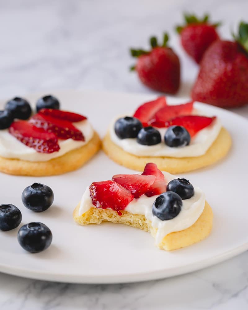 Mini fruit pizza with white chocolate cream cheese frosting - ultimate classic summer dessert in bite-size! It's a perfect make-ahead dessert for a crowd! #fruitpizza #minifruitpizza
