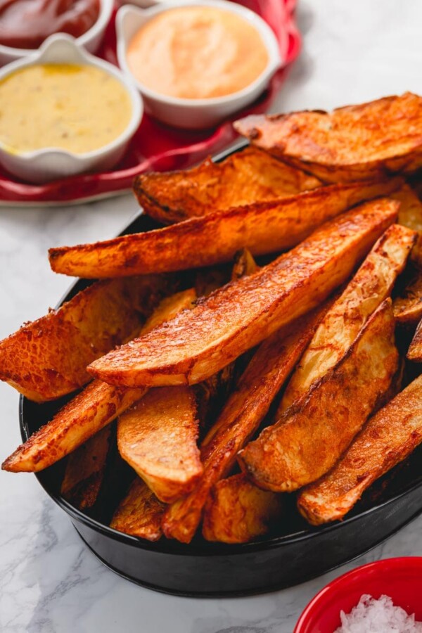 These baked steak fries are outrageously delicious! Super crispy on the outside and thick and fluffy on the inside. The secret mixture ensures these baked fries come out ultra-crispy every time! #steakfries #bakedfries
