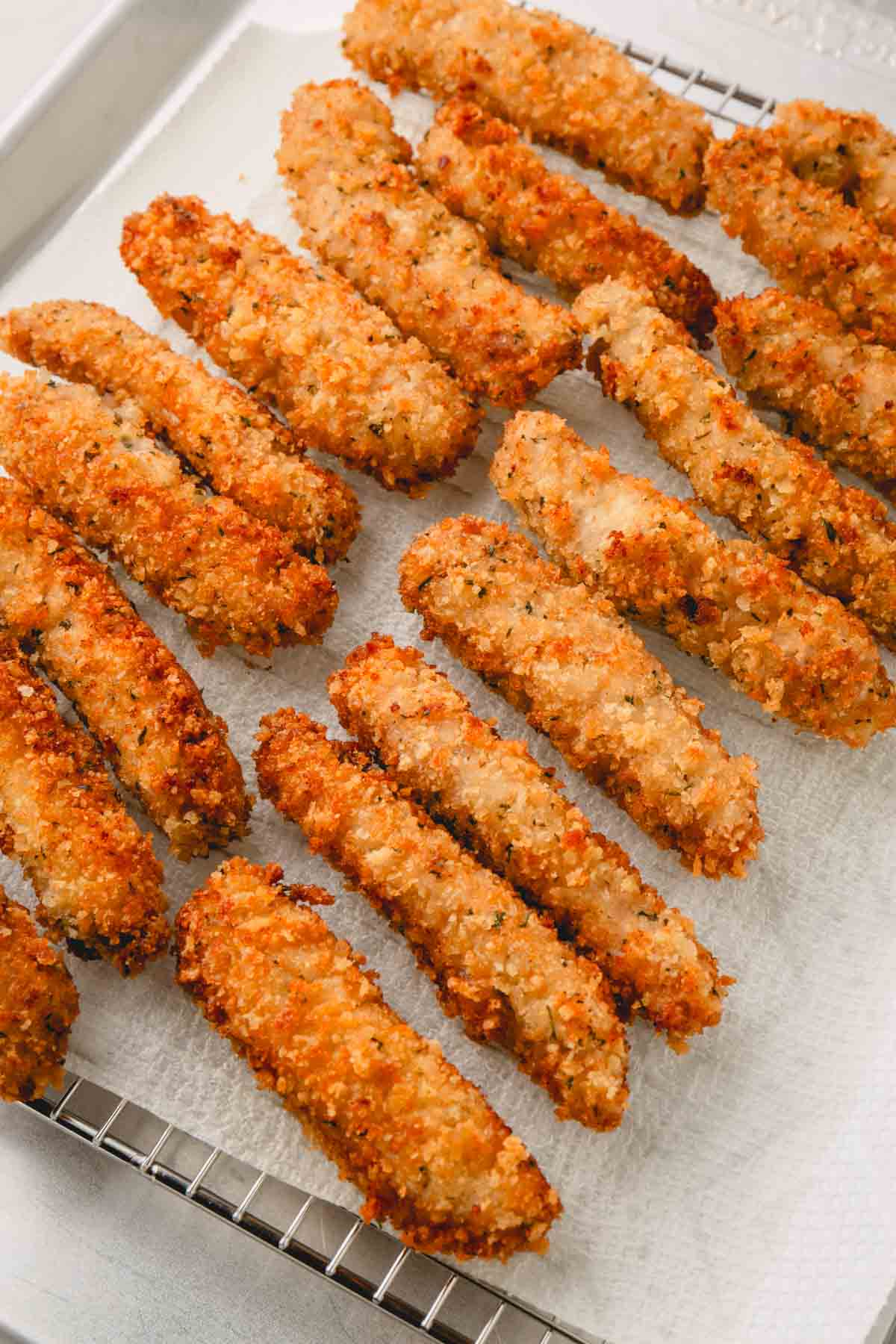 Fried pork strips draining on a paper towel.