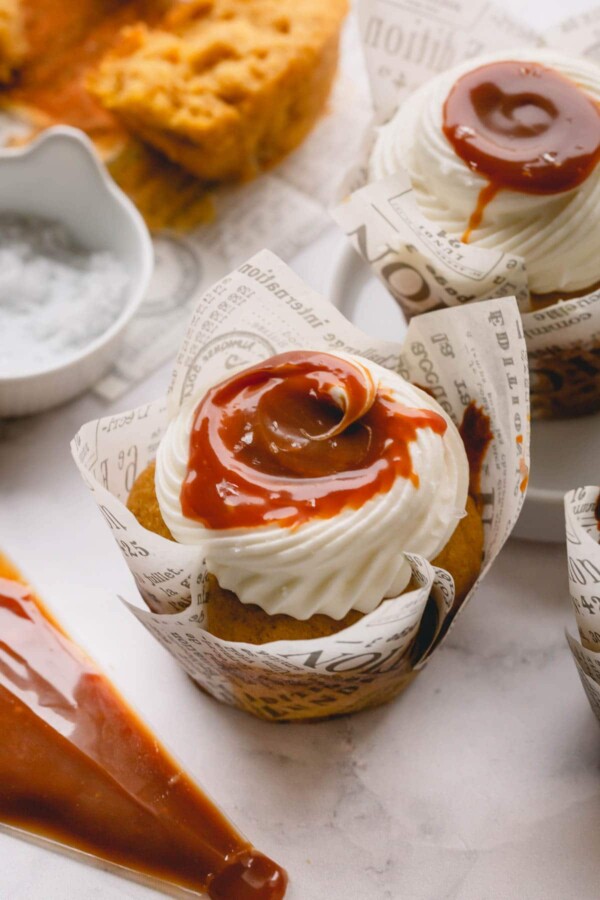 Pumpkin cupcake topped with cream cheese frosting and salted caramel.