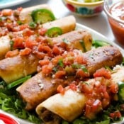 A plate of leftover pulled pork flautas topped with pico de gallo.