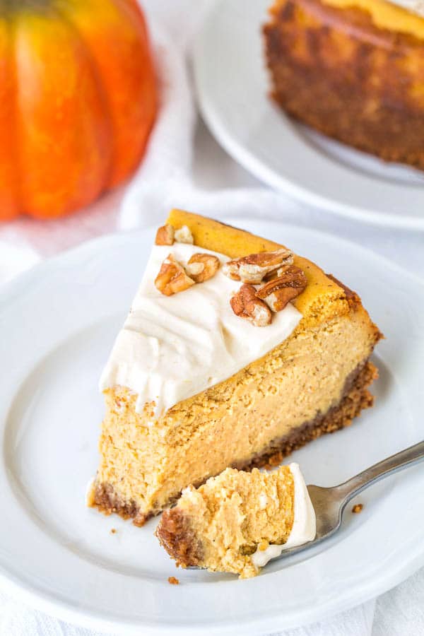 Irresistibly creamy pumpkin cheesecake, sweetened with maple syrup and smeared with maple pumpkin whipped cream frosting. It's your next favorite fall dessert!