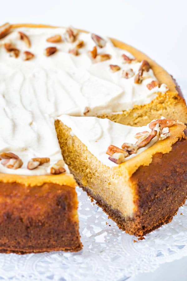 Creamy maple pumpkin cheesecake - a whole cake with one slice cut. 