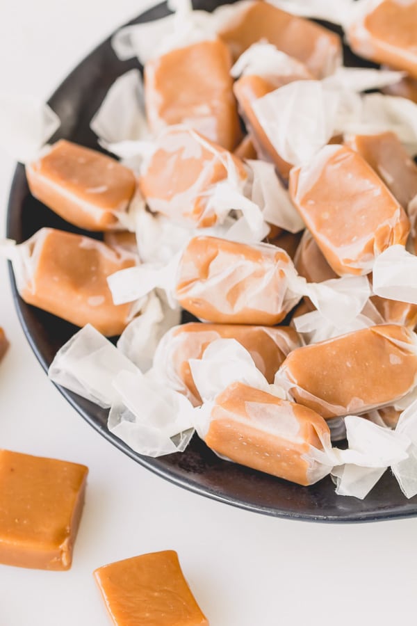 These buttery, soft and chewy caramels, infused with hint of cardamom, are so delightfully addicting!! Step-by-step photos and lots of tips included. #caramels #homemadecaramels