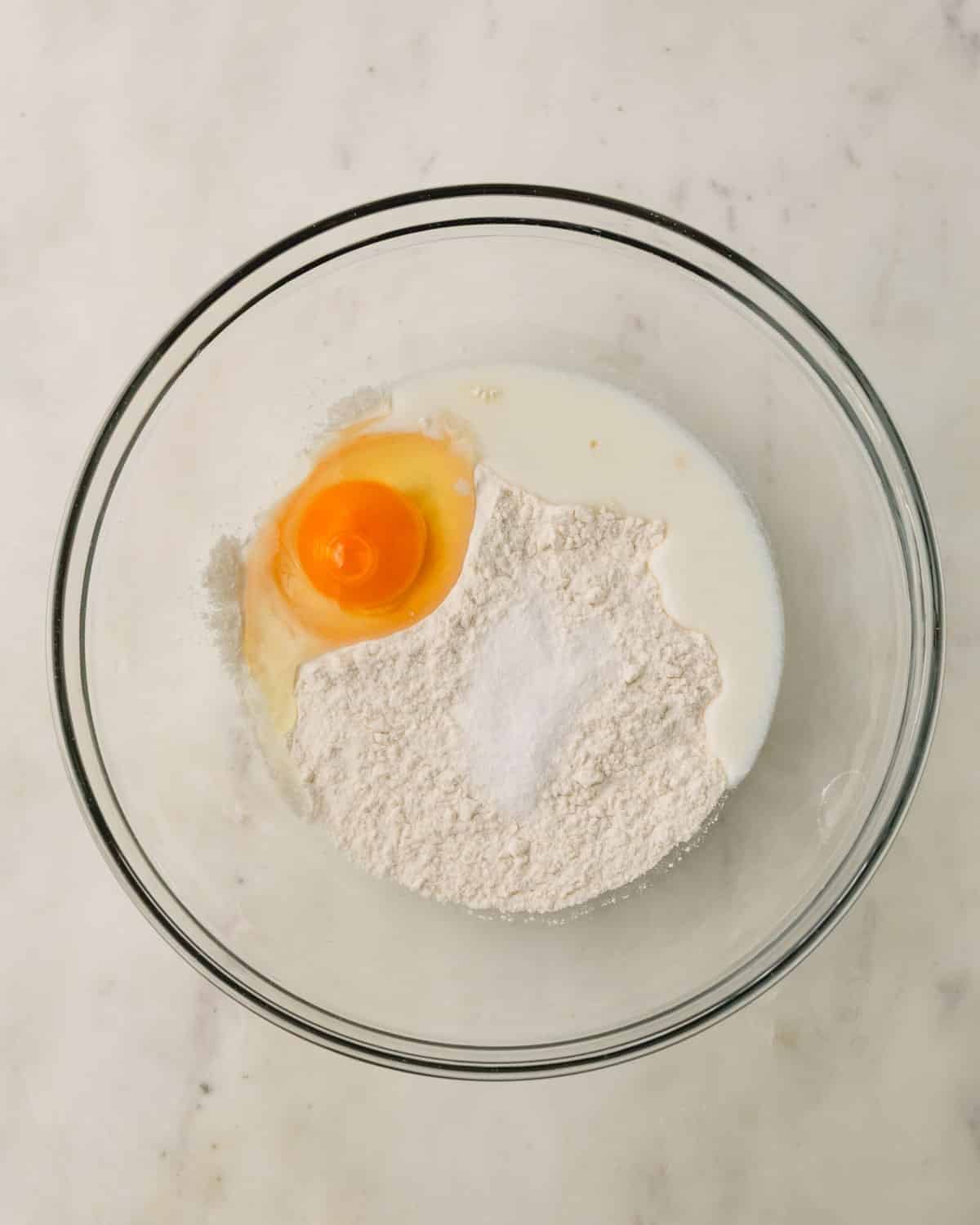 Knoephla ingredients dumped in a glass mixing bowl.