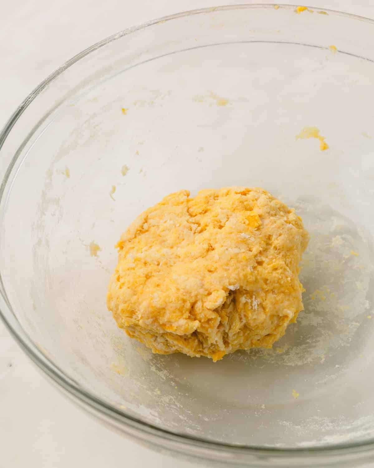Shaggy knoephla dough formed in a glass mixing bowl.