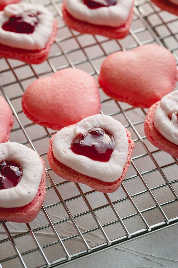 These strawberry macarons are infused with strawberry flavor in every layer (no artificial flavoring)!  So good, you wouldn't want to share these adorable little heart-shaped treats! #strawberrymacarons #frenchmacarons 