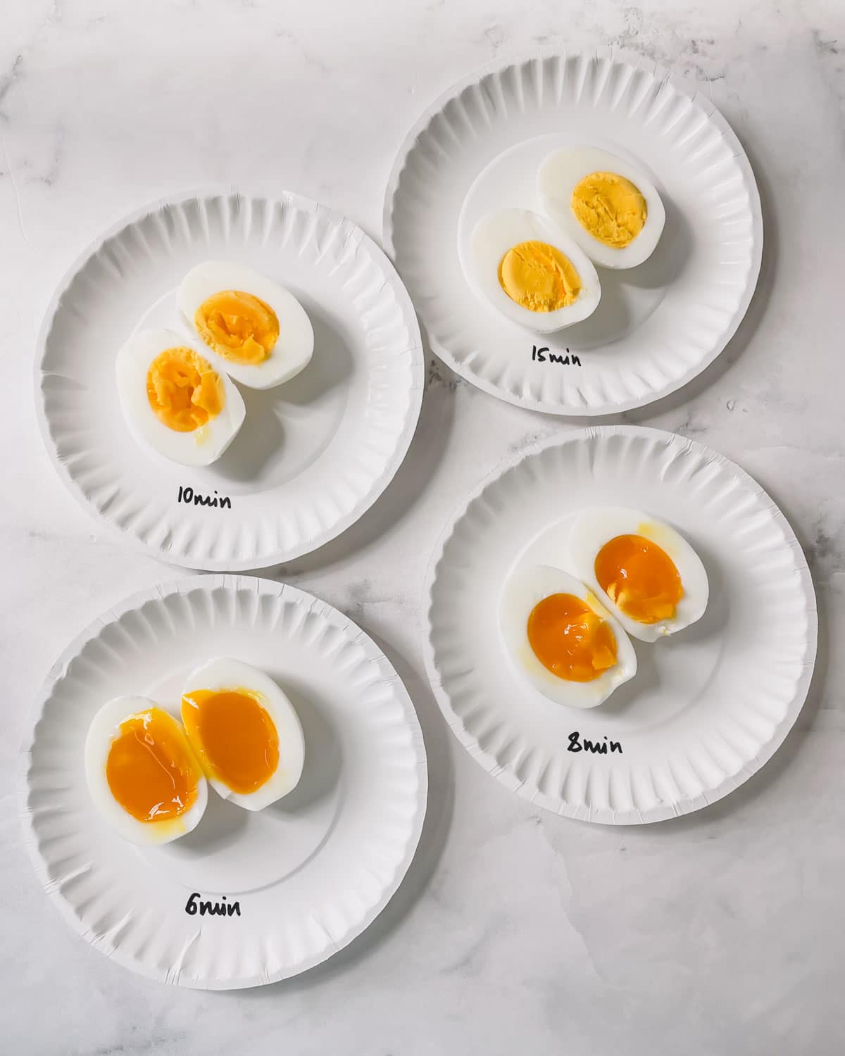 Hard boiled eggs time chart: 4 plates of hard boiled eggs of various doneness.