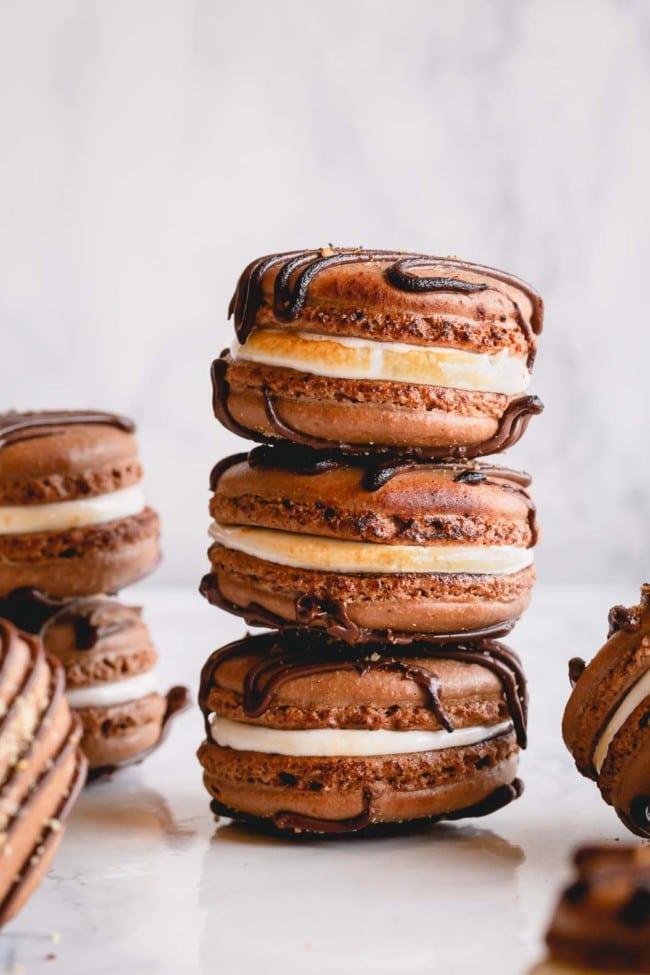Filled s'mores macarons arranged on a counter.