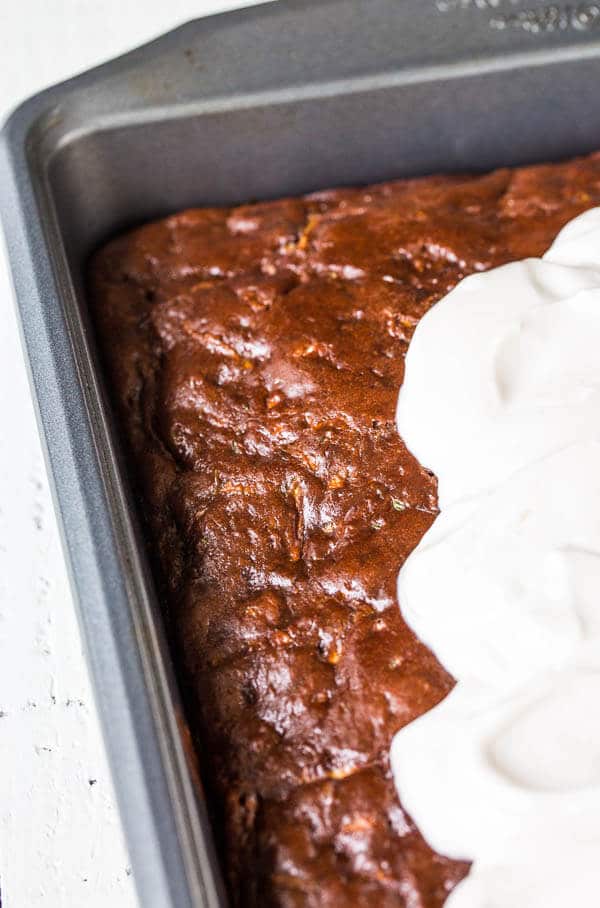 This double chocolate zucchini sheet cake is an effortless way to feed a crowd! No mixer required. Plus, your guests won't even know there's zucchini in the cake!