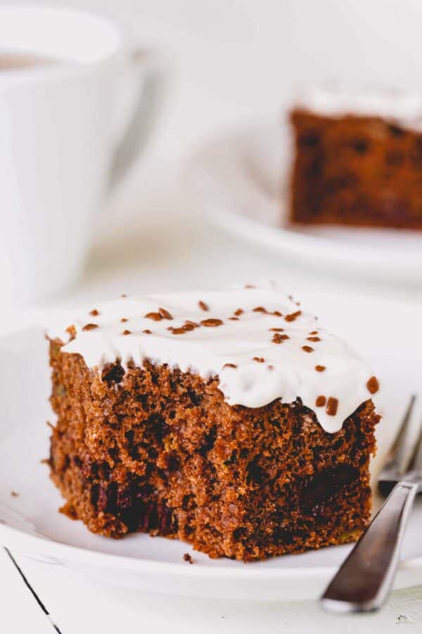 A square slice of double chocolate zucchini cake with a bite missing.