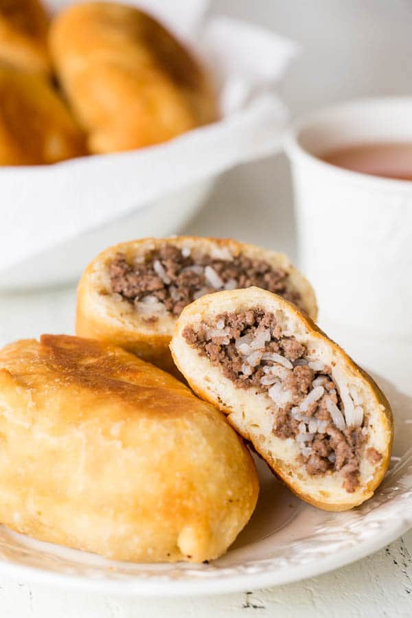 Perfect for picnics, potlucks and any summer activities, these Russian piroshki (meat hand pies) are made of tender and soft dough, filled with simple meat and rice mixture and fried till crisp golden perfection!