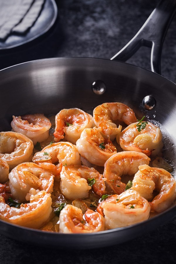 Plump, succulent shrimp sautéed in an aromatic garlic butter - a perfect dinner in minutes. Watch for these visual cues for perfectly cooked soft shrimp! #garlicbuttershrimp #shrimprecipe