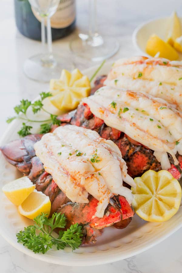 Baking these beautiful lobster tails in white wine brings out the succulent sweet flavors perfectly and yields melt-in-your-mouth tender meat every time. The easiest way to cook lobster tail! #lobstertails #bakedlobstertails