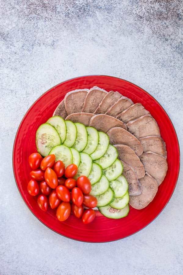 Thinly sliced beef tongue is a popular Mongolian appetizer, often served with cucumbers and tomatoes.