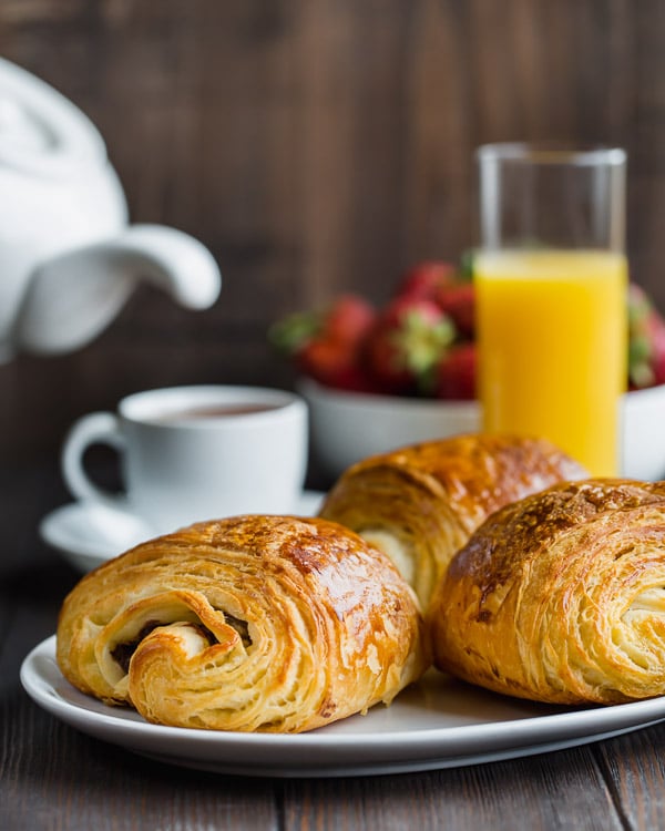 Step by step tutorial for flaky, buttery chocolate croissants. #painauchocolat #homemadechocolatecroissant #croissant