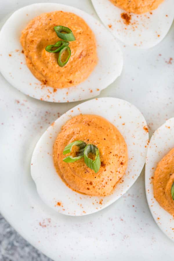 Roasted red pepper deviled eggs with ultra-smooth, creamy filling. The classic deviled egg recipe with big bold flavors and a spicy kick! #roastedredpepper #deviledeggs #easyappetizer