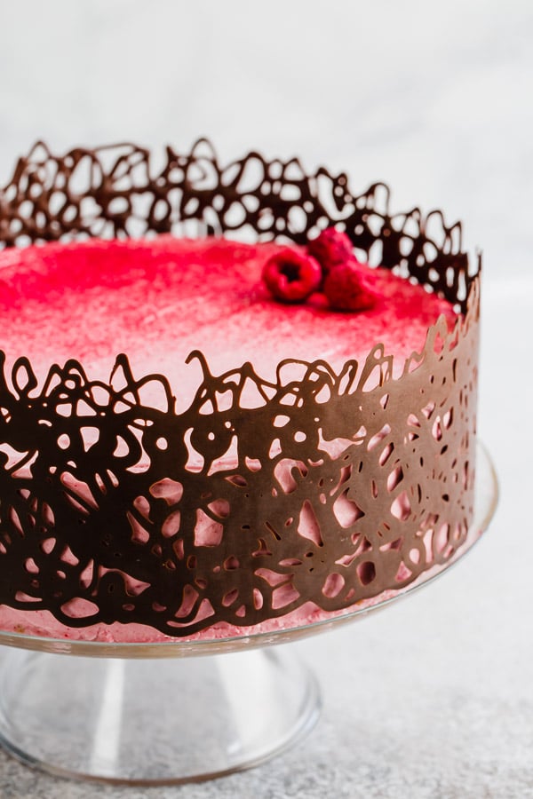 There's nothing boring about this classic vanilla layer cake. Paired with sweet and tart raspberry cream cheese frosting, this cake is a winner. #birthdaycake #vanillacake #layercake #raspberrycreamcheesefrosting #creamcheesefrosting