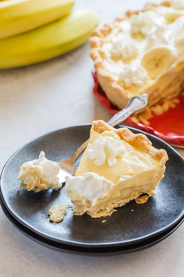 All-American, old-fashioned, 100% from scratch banana cream pie featuring flaky buttery pie crust, silky smooth vanilla pudding, plenty of bananas and homemade whipped cream. Seriously so delicious and can totally be prepared in advance! #bananacreampie #homemadepie #pie #homemadevanillapudding #piecrust
