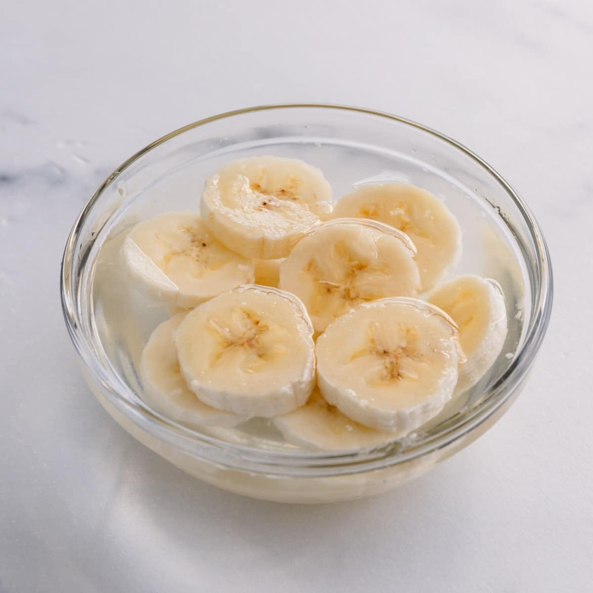 banana slices in a small bowl with lemon water.