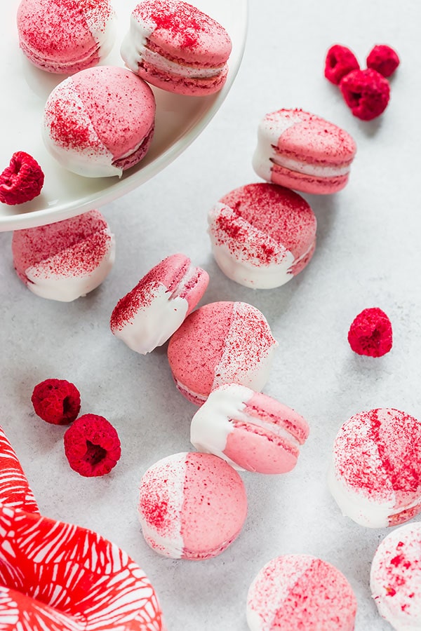 Easy to follow, detailed, step-by-step recipe for white chocolate raspberry macarons. You'll love biting into these heavenly treats bursting with flavor! #frenchmacaron #macarontutorial #raspberrymacarons #macarons