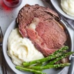 A plate of boneless prime rib roast, mashed potatoes, and asparagus.