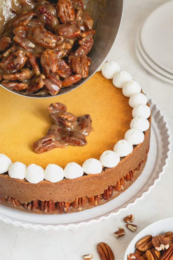Incredibly indulgent, this pecan pie cheesecake consists of buttery nutty crust, super tall New York-style cheesecake and rich pecan pie topping! A perfect centerpiece for your holiday dessert table. #cheesecake #pecanpiecheesecake #ThanksgivingDessert
