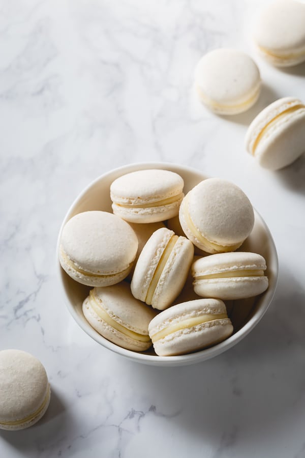 A bowl of white assembled macarons.