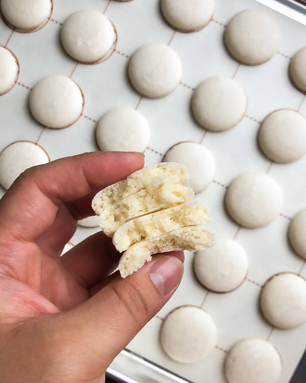 These gorgeous white macarons, filled with silky smooth white chocolate ganache, are pure dream for every macaron lover! Grab a coffee and read my recipe testing notes to get these pure white macarons. #macarons