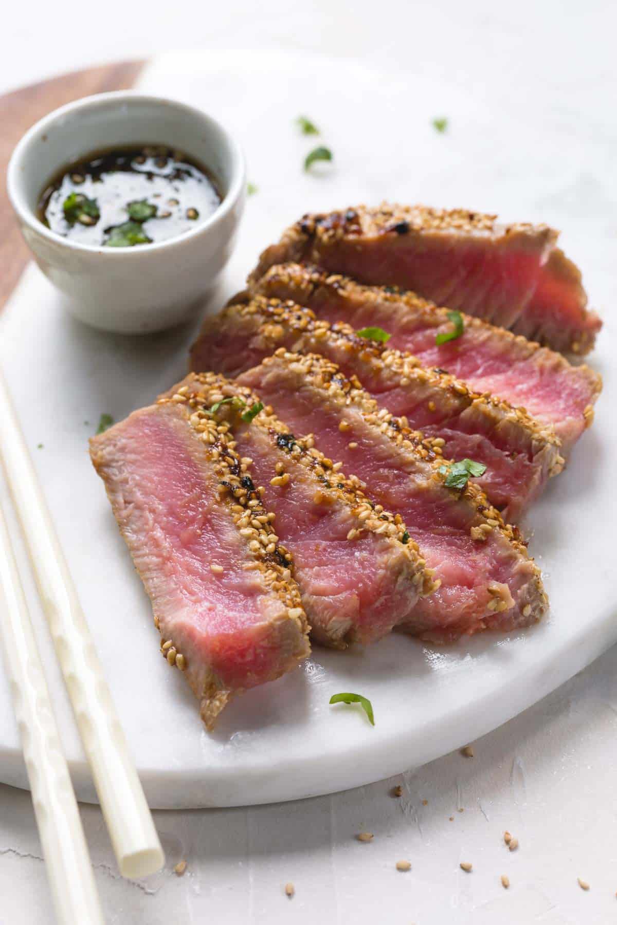 Seared and sliced ahi tuna with sesame crust on a platter.