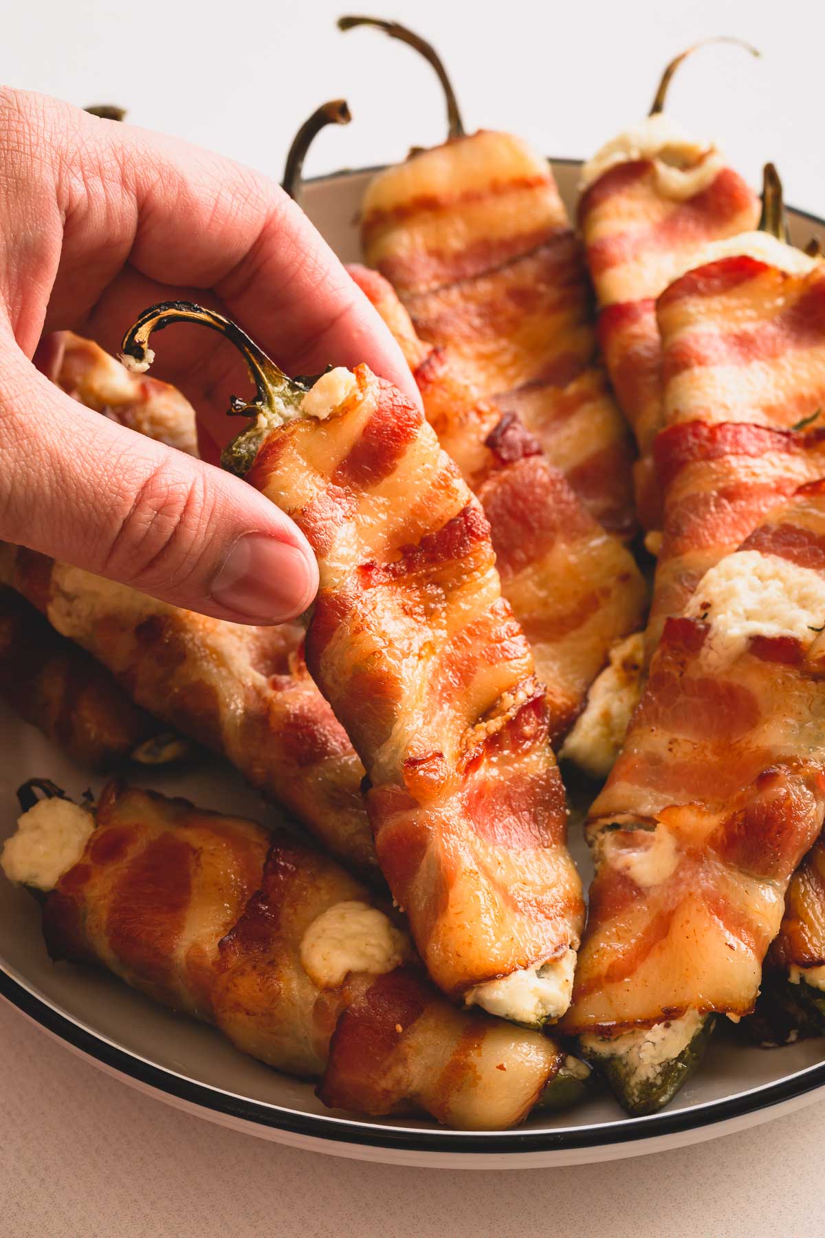 Bacon wrapped jalapeno poppers on a platter.