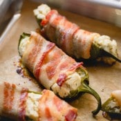 Cooked bacon jalapeno poppers on a baking sheet.
