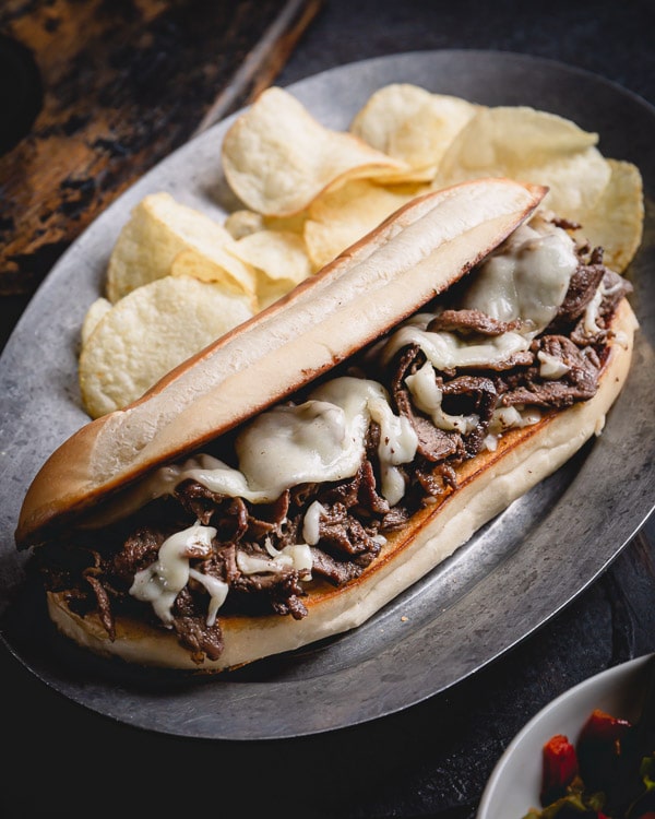 Super quick and easy Philly cheesesteak recipe with indulgent provolone cheese sauce! Let me show you how to make practically fail-proof cheese sauce, so you too can make weeknight dinner a little more special. #philycheesesteak