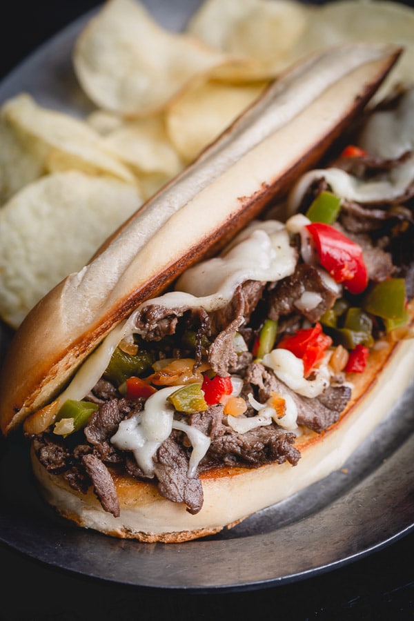 Super quick and easy Philly cheesesteak recipe with indulgent provolone cheese sauce! Let me show you how to make practically fail-proof cheese sauce, so you too can make weeknight dinner a little more special. #philycheesesteak #phillycheesesteaksandwiches