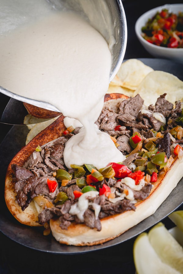 Super quick and easy Philly cheesesteak recipe with indulgent provolone cheese sauce! Let me show you how to make practically fail-proof cheese sauce, so you too can make weeknight dinner a little more special. #philycheesesteak #cheesesauce
