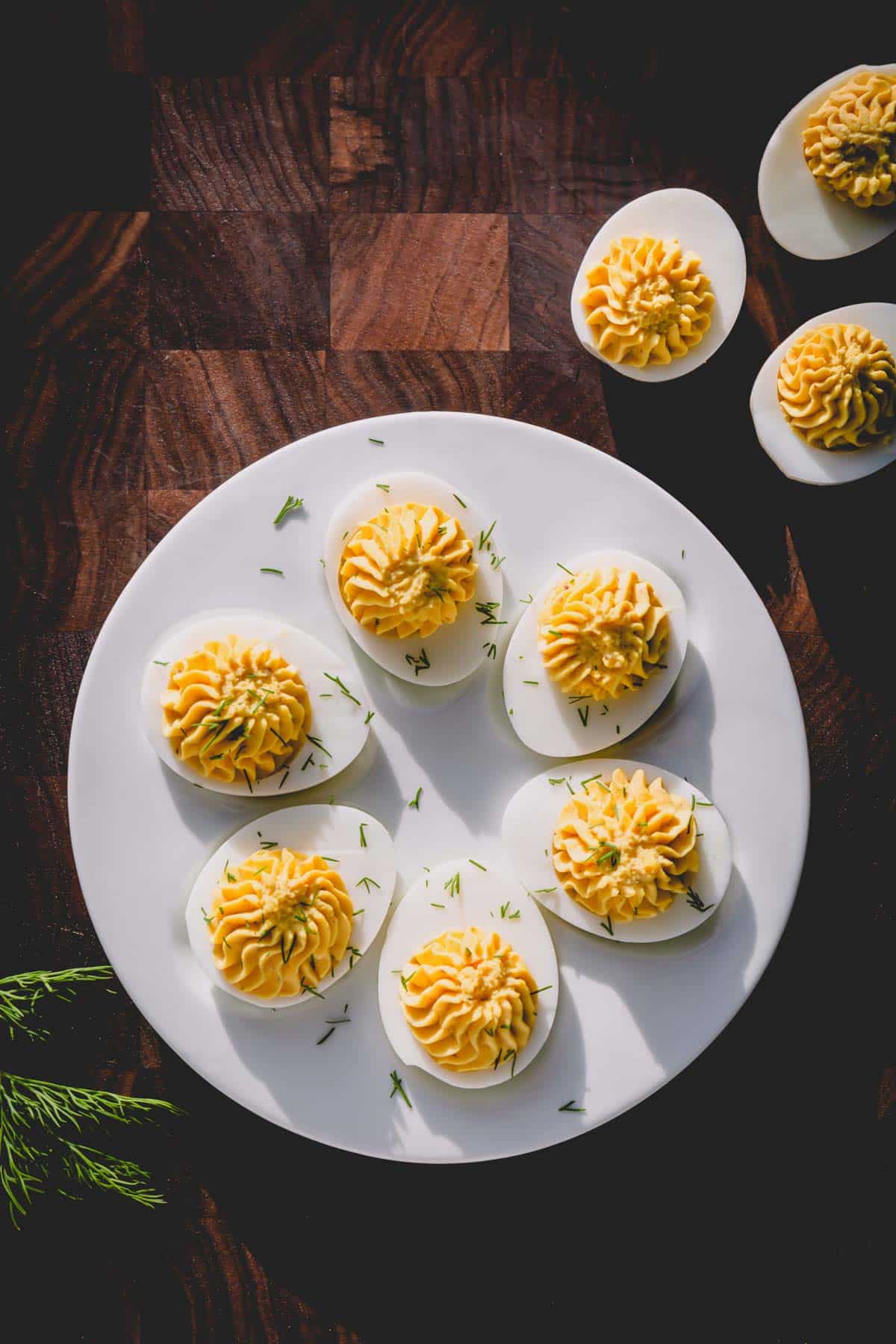 Deviled eggs on a white serving platter.