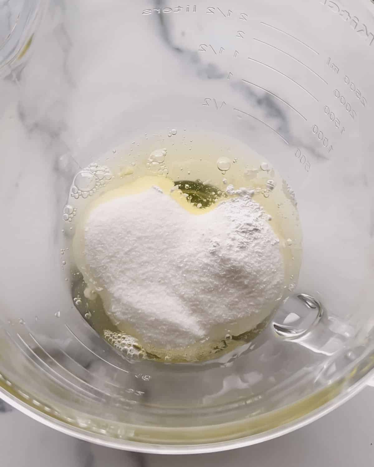 Egg whites, sugar, cream of tartar, and salt in a glass mixing bowl.