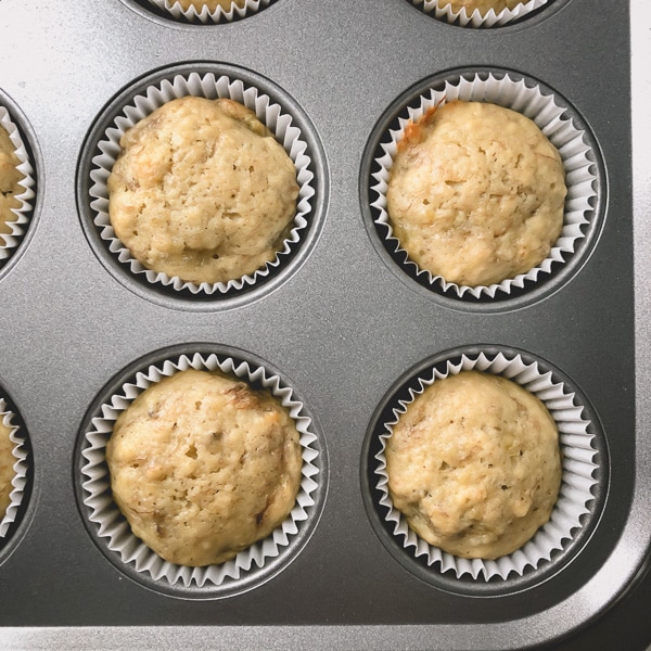 Very pale baked banana muffins in a baking pan.