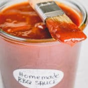 A jar of bbq sauce with a brush