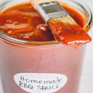 A jar of bbq sauce with a brush