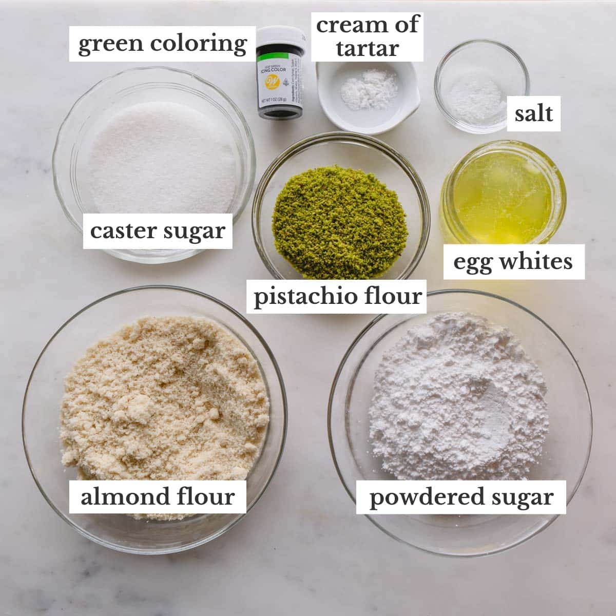 Ingredients for pistachio macaron shells in individual bowls.