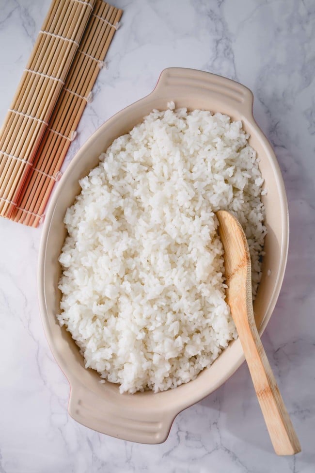 sushi rice serve in a dish with a wooden spoon
