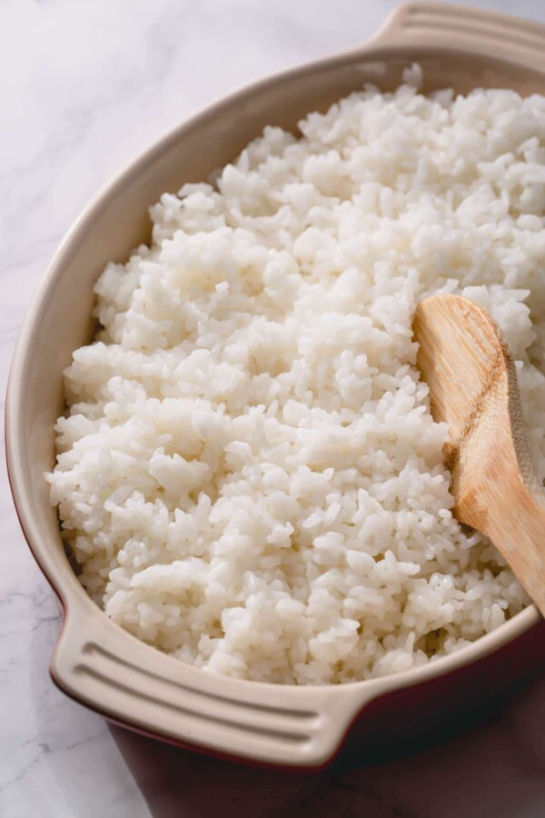 sushi rice in a dish with a wooden spoon