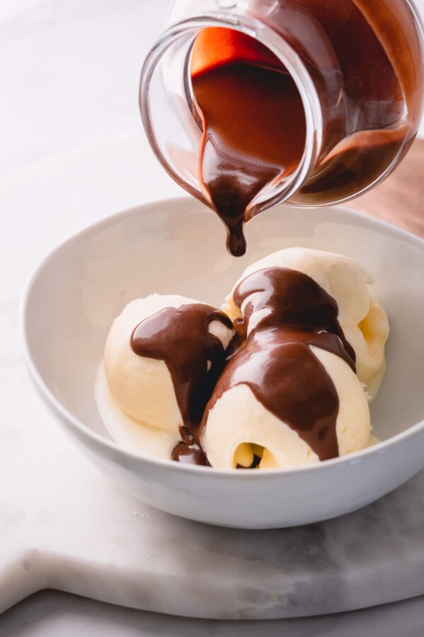 Three scoops of vanilla ice cream with chocolate sauce 